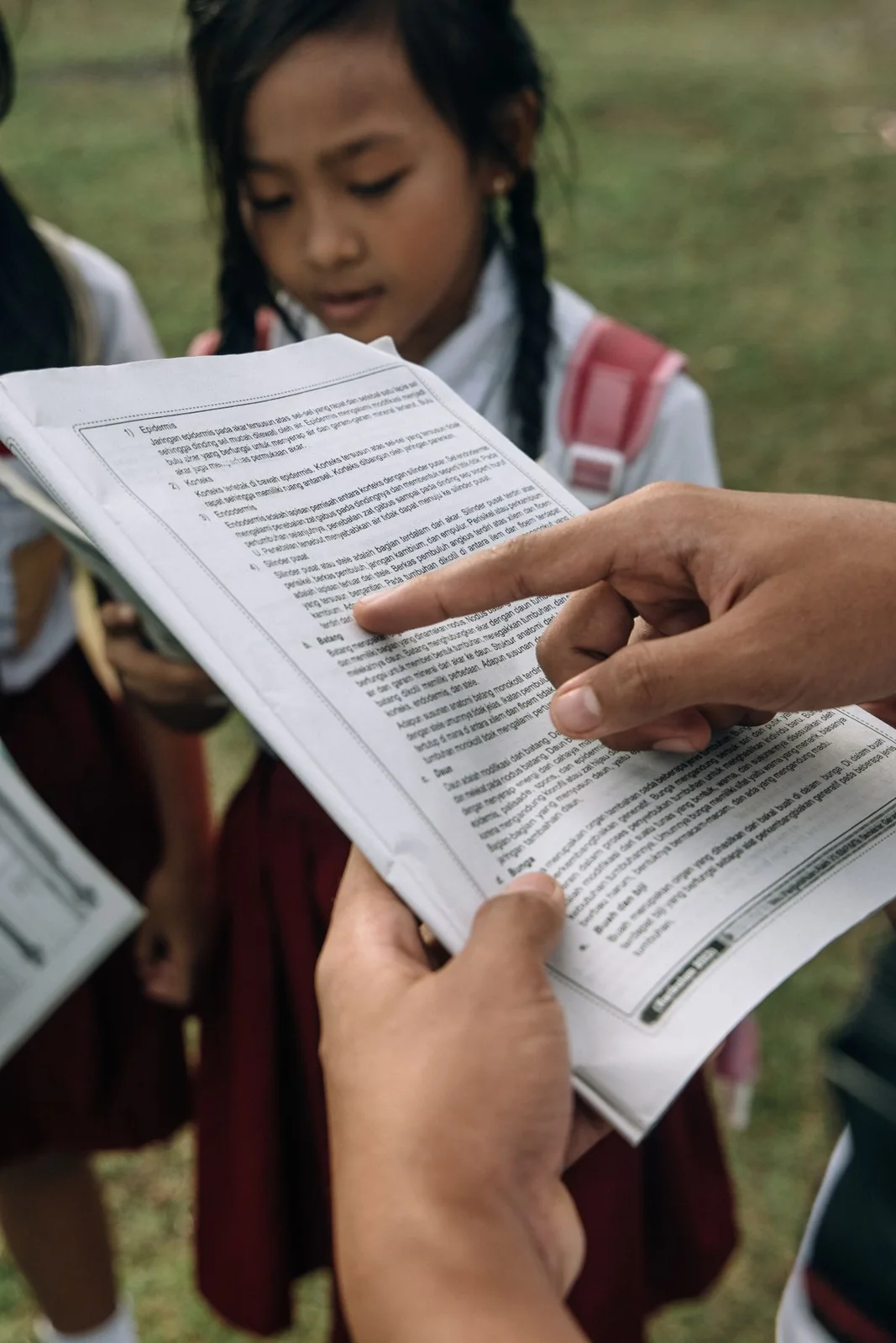 Teacher showing a book to children in school uniforms
