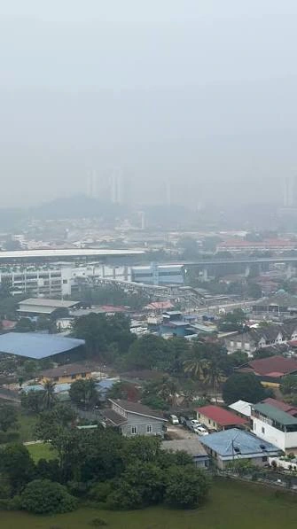 Haze obscuring buildings beyond homes and trees