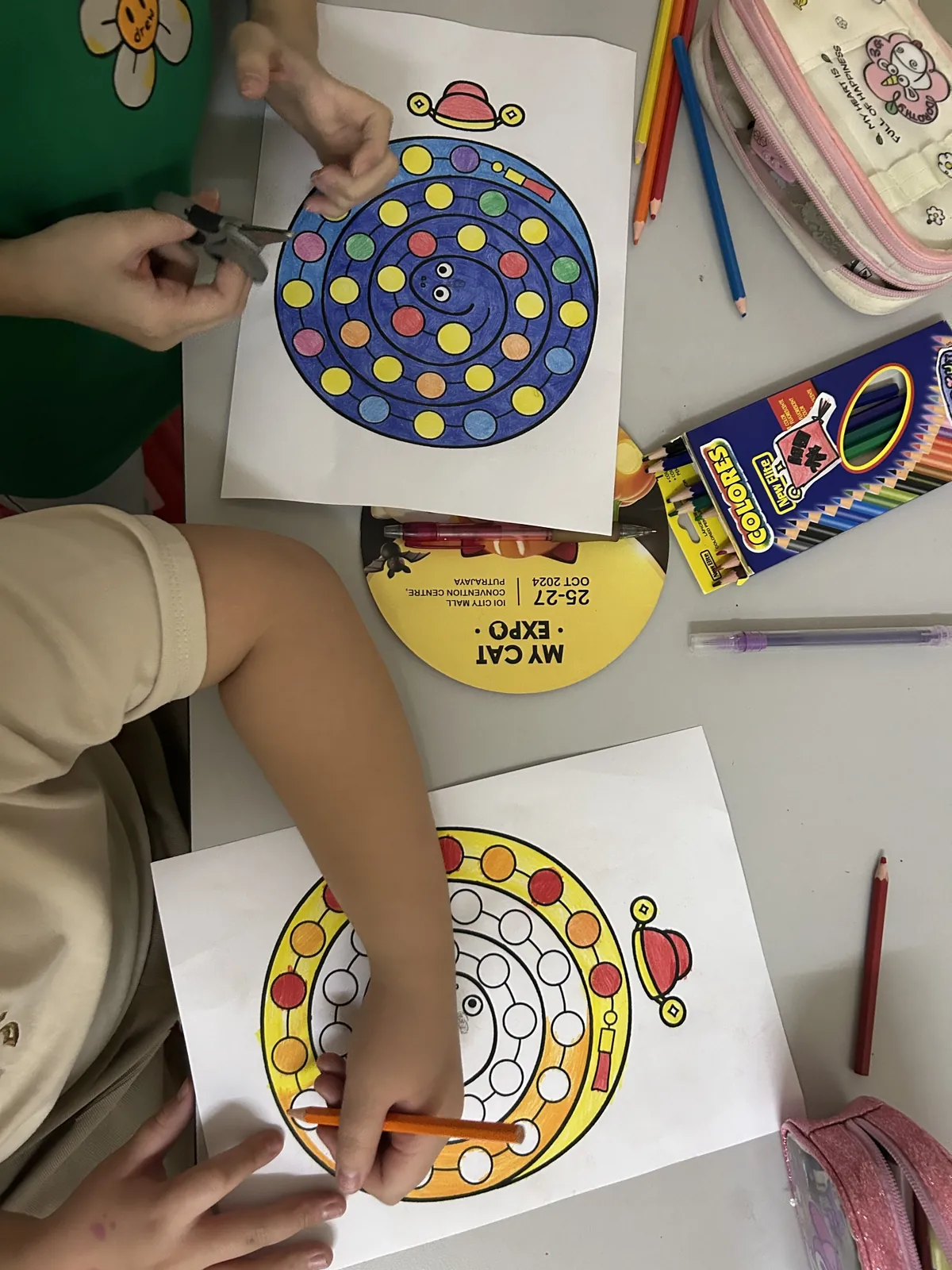Children colouring and cutting out snake crafts at myKiwi in Kajang