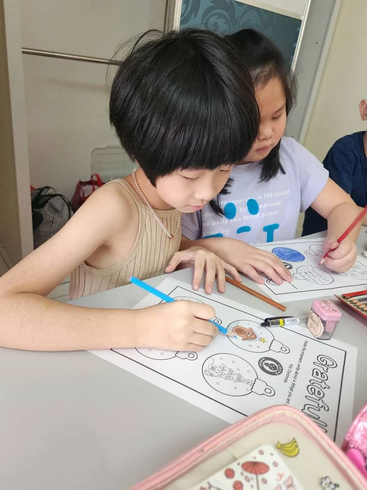 Children colouring activity worksheets together at a table