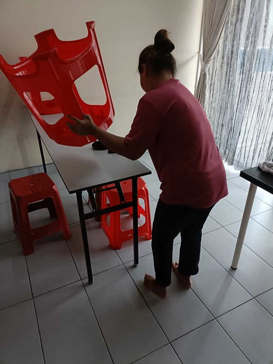 myKiwi team member cleaning and arranging classroom chairs in Kajang