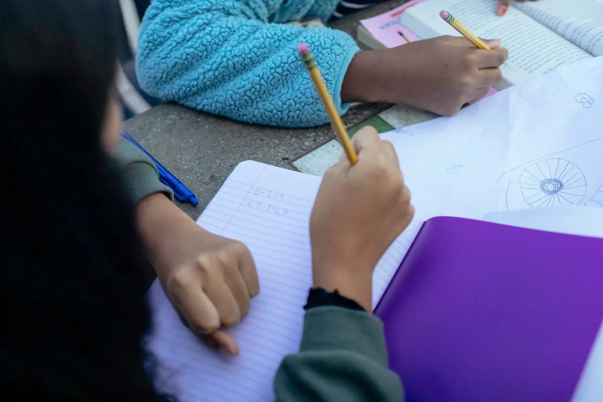 Children writing in exercise books together