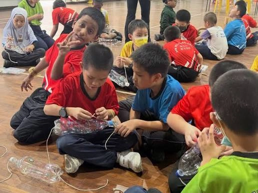 Children working together on a hands-on activity with plastic bottles